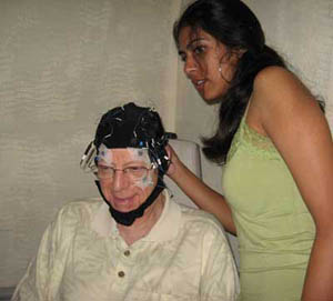 Undergraduate Farheen Checks EEG Electrodes on Older Adult
